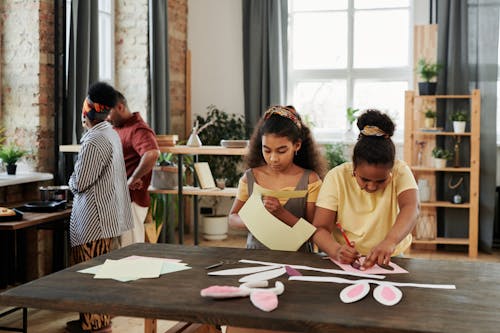 Children Doing Easter Crafts and Parents Standing in the Background 