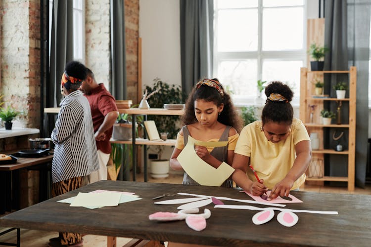 Children Doing Easter Crafts And Parents Standing In The Background 