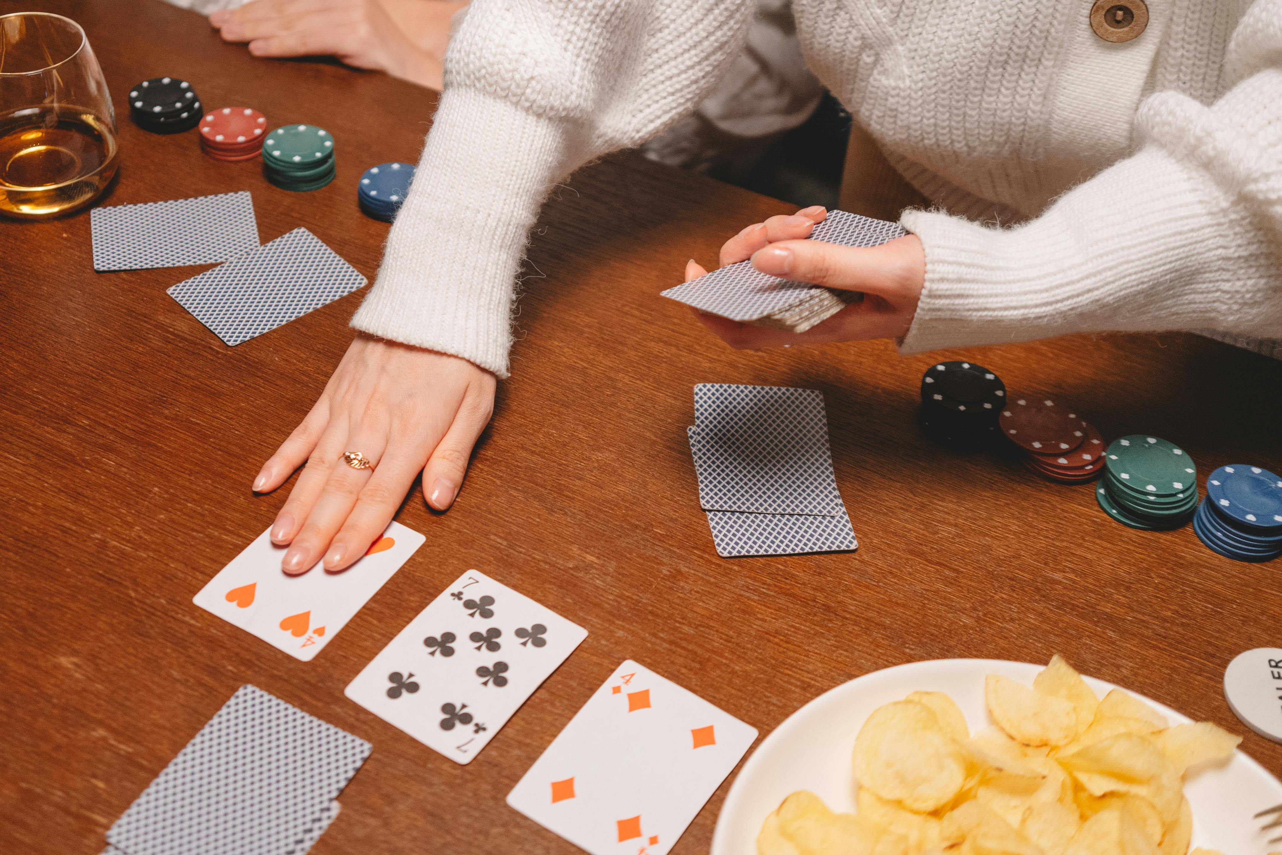 person in white long sleeve shirt holding playing cards