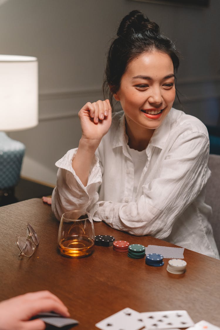 Woman Playing Poker On The Wooden Table