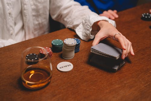 Person Wearing White Long Sleeve Shuffling the Cards