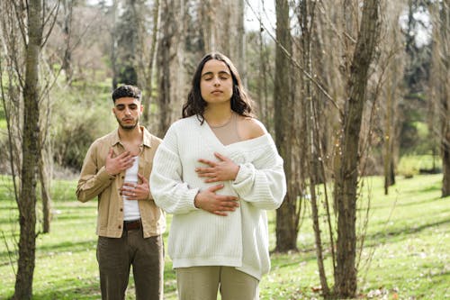 A Man and a Woman Meditating While Standing