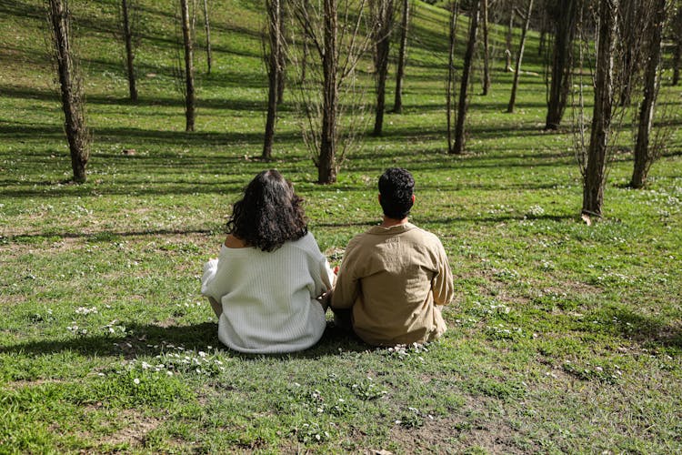 Young Man And Woman Doing Yoga In The Park