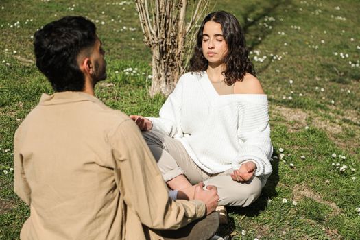 A couple meditating in a serene outdoor environment promoting tranquility and relaxation.