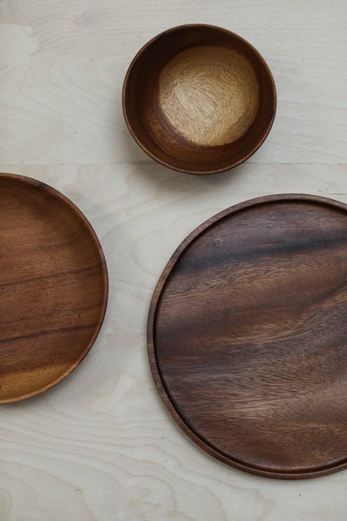 A Wooden Bowl and Plates on a Flat Surface