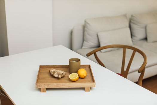 Elegant minimalist composition featuring lemons and ginger on a wooden tray indoors.