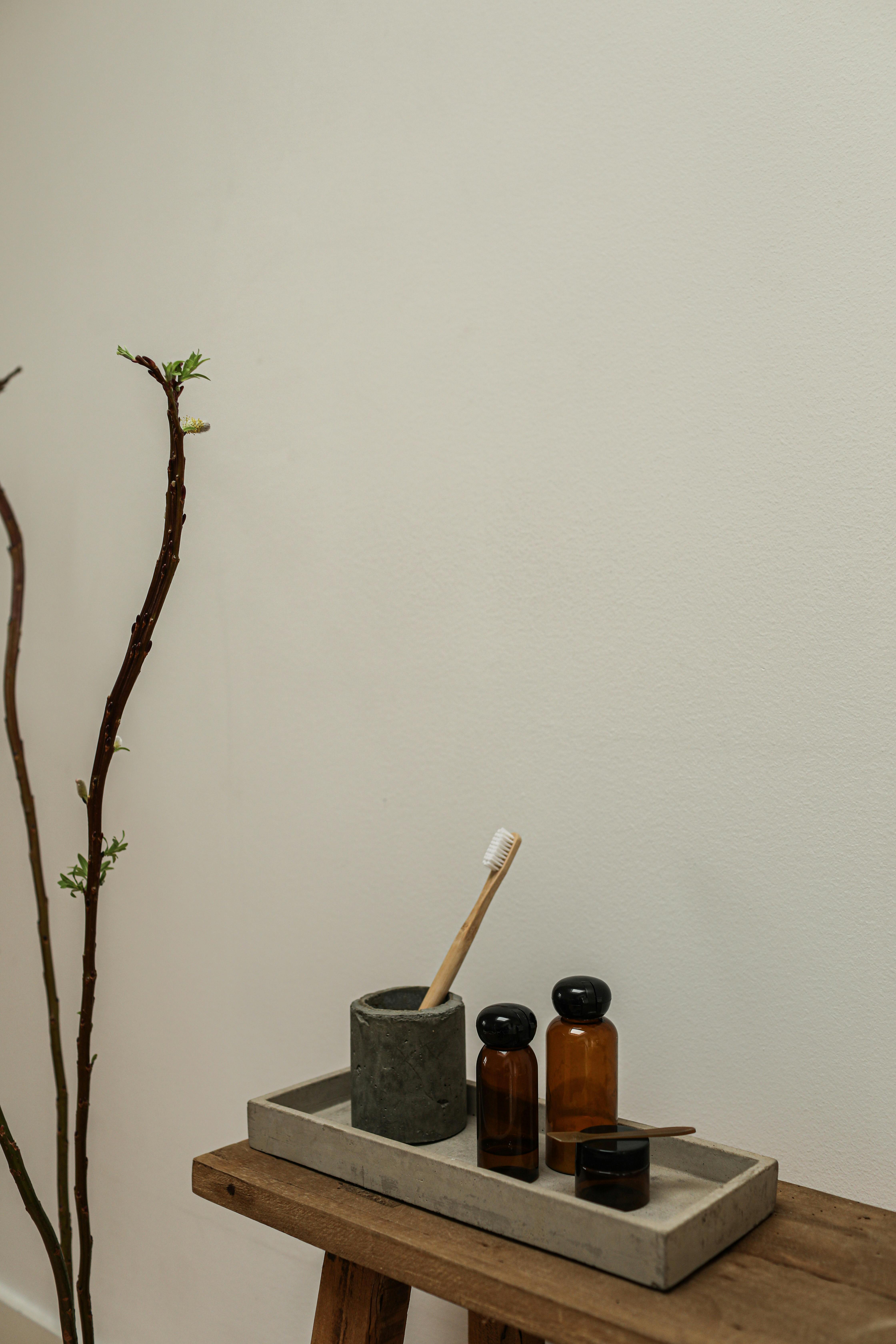 A minimalist bathroom setup featuring rustic elements, eco-friendly toothbrush, and retro cosmetics.