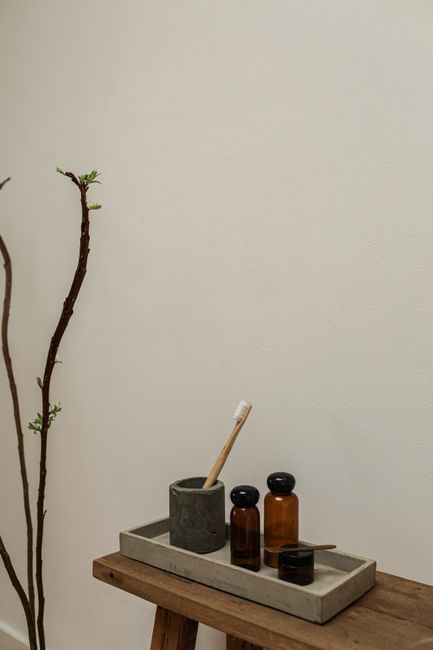 A minimalist bathroom setup featuring rustic elements, eco-friendly toothbrush, and retro cosmetics.