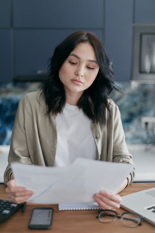 Free Woman in Gray Long Sleeves Looking at the Papers Stock Photo