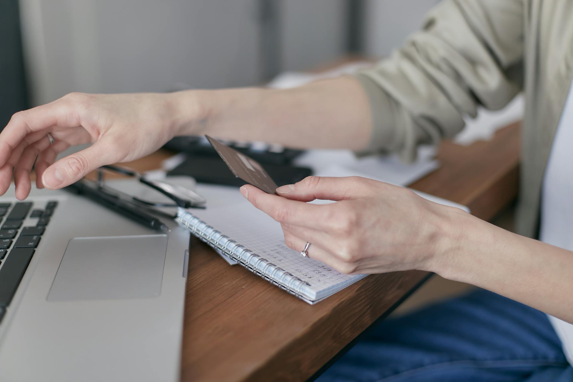 A person using a credit card on a laptop for online shopping or payment.