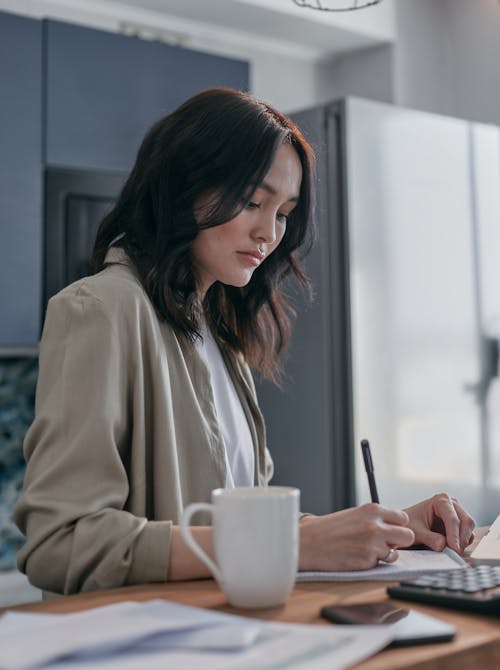 Serious Woman Writing on a Notebook 