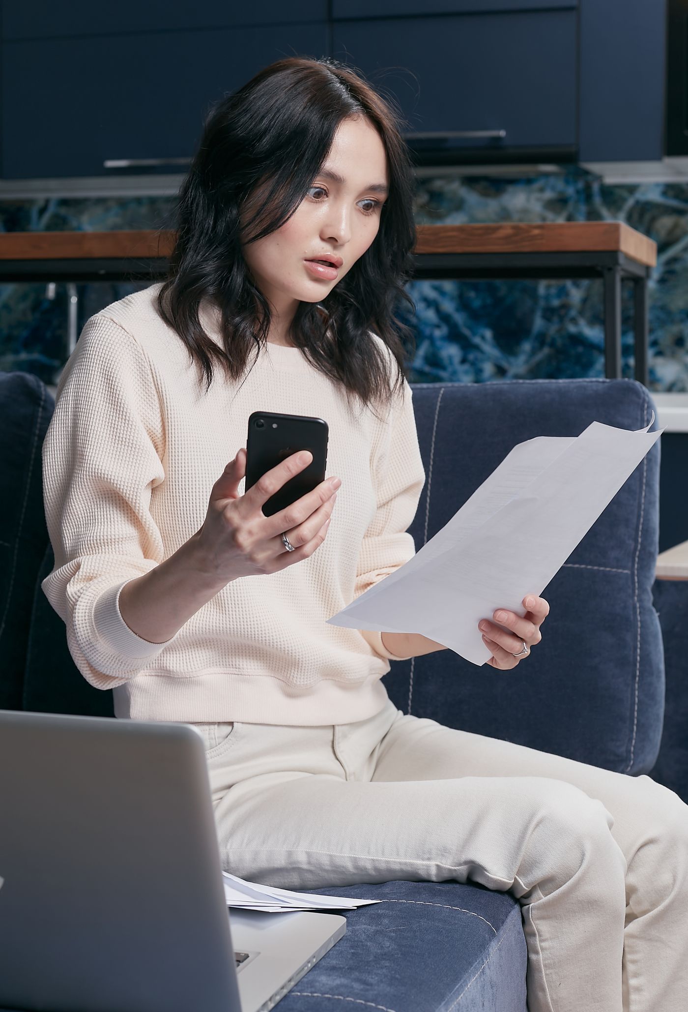 Người trẻ kiểm tra tài chính cá nhân trên điện thoại và máy tính xách tay