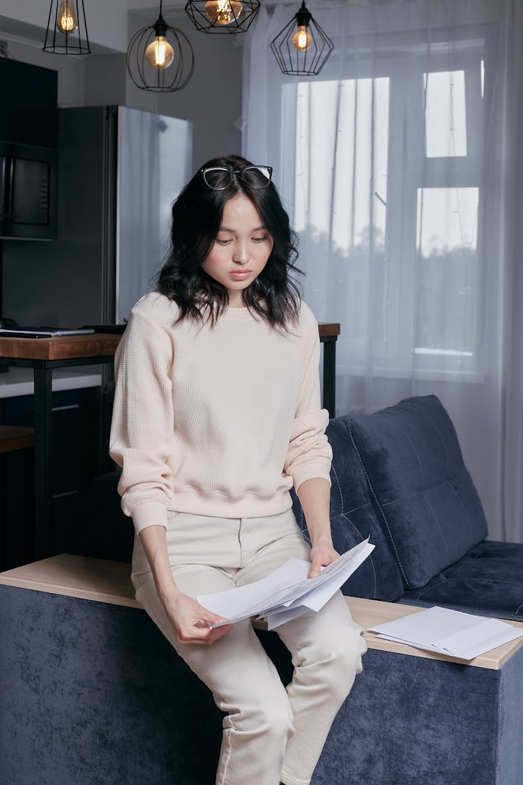 Problematic Young Woman Holding Tax Papers 