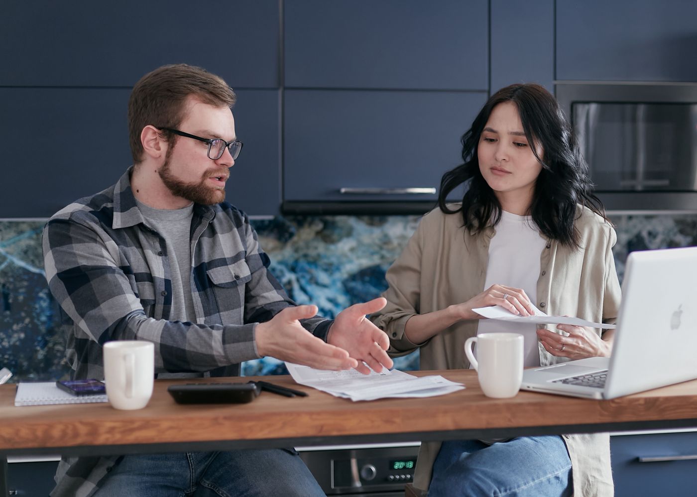 Hai người kiểm tra hóa đơn và tình hình tài chính tại nhà
