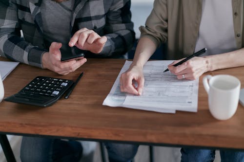 Free Two People Doing Paperwork and Computing Taxes Stock Photo