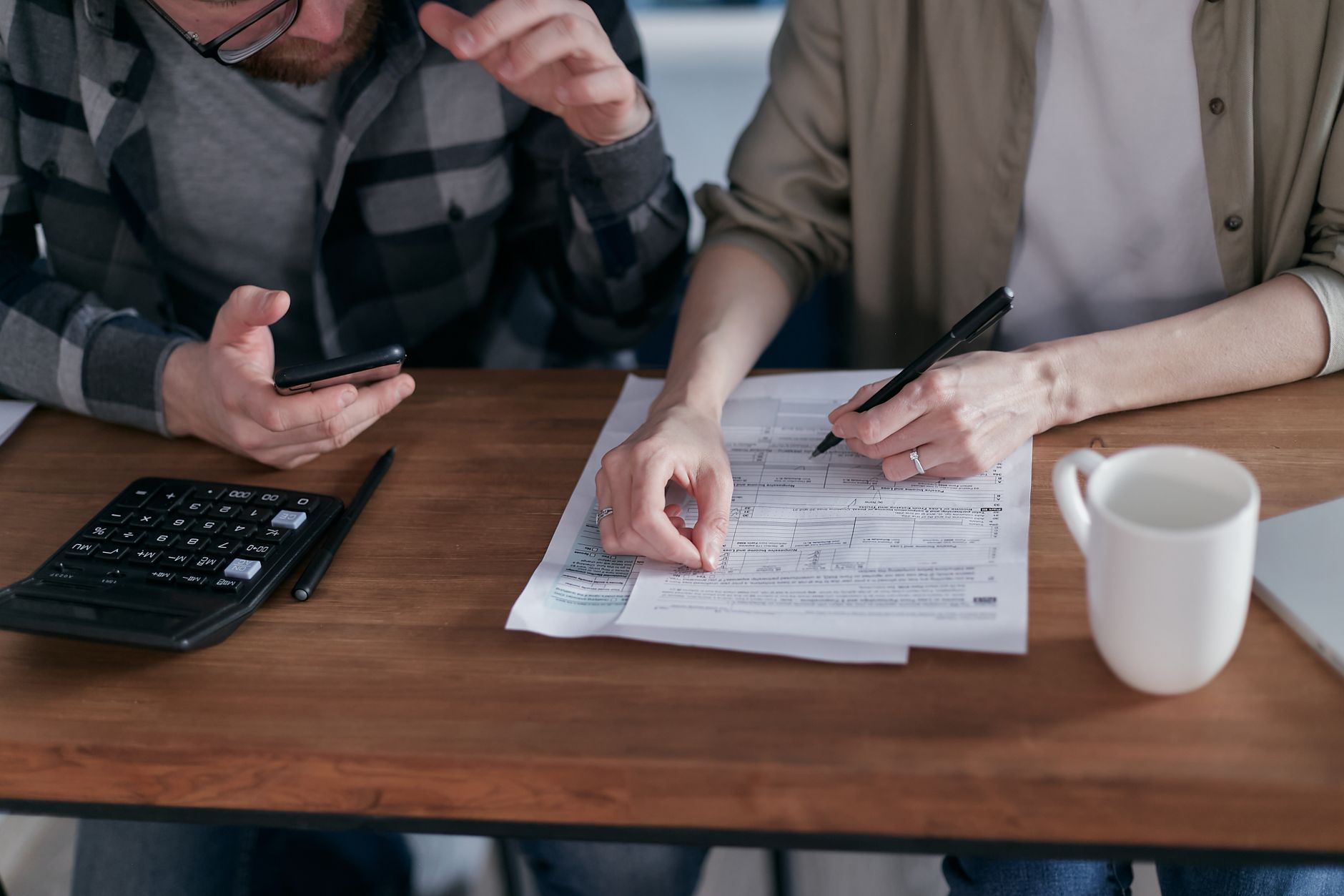 실업급여 예상 수령액 계산기 4 A couple collaboratively managing finances with papers and calculator in hand.