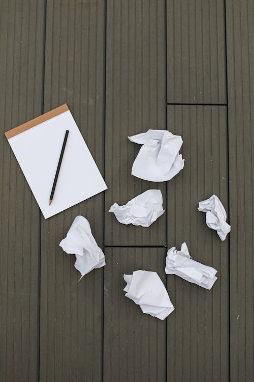 Blank Notepad and Scrunched Paper Lying on the Floor 