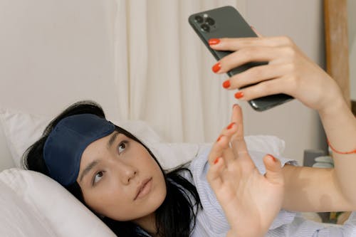 Free A Woman Looking at Her Smartphone Stock Photo