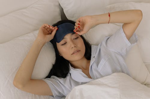 Free Woman in a Sleep Mask Waking up in her Bed Stock Photo