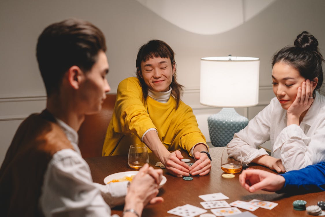 Free People Playing Poker on Wooden Table Stock Photo