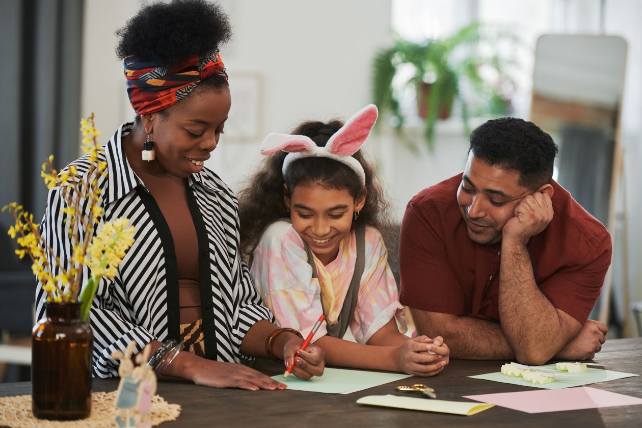 Parents helping their school-aged daughter with a creative project