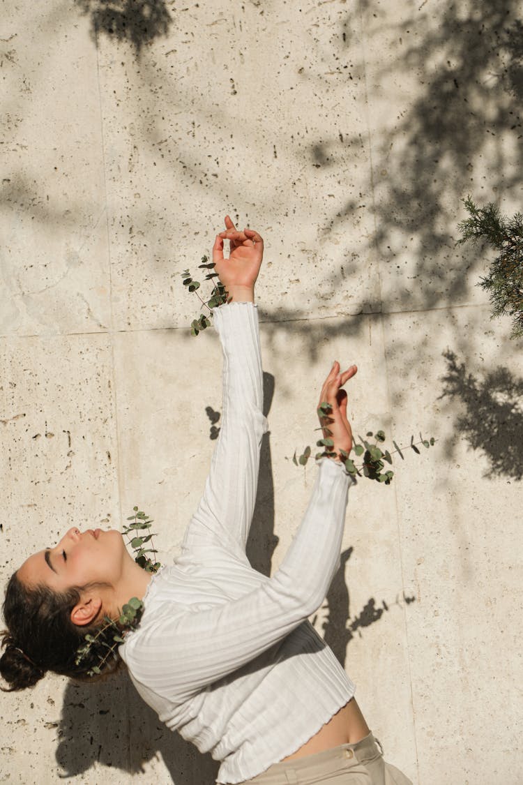 A Girl In White Long Sleeve Shirt Bending Backwards