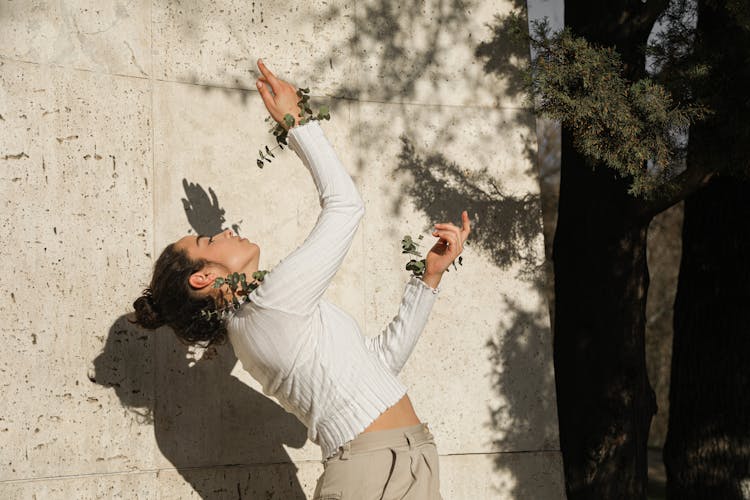 A Girl In White Long Sleeve Shirt Bending Backwards