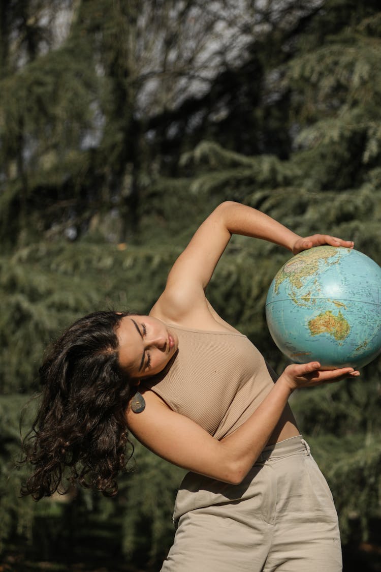 Girl In Top Holding A Globe