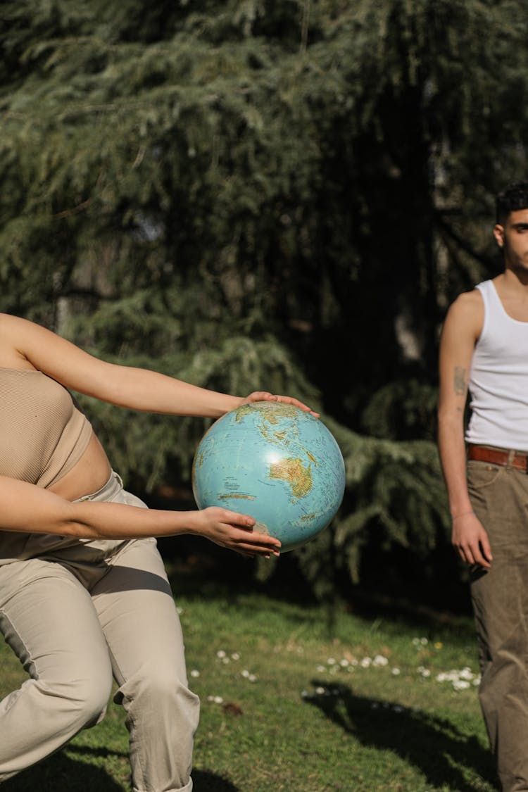 A Person In Brown Crop Top Holding A Globe