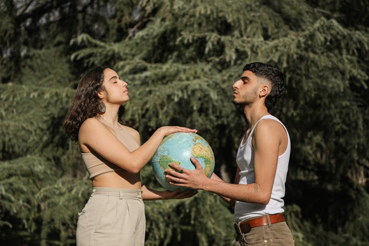 A Man And A Woman With Eyes Closed Holding A Globe