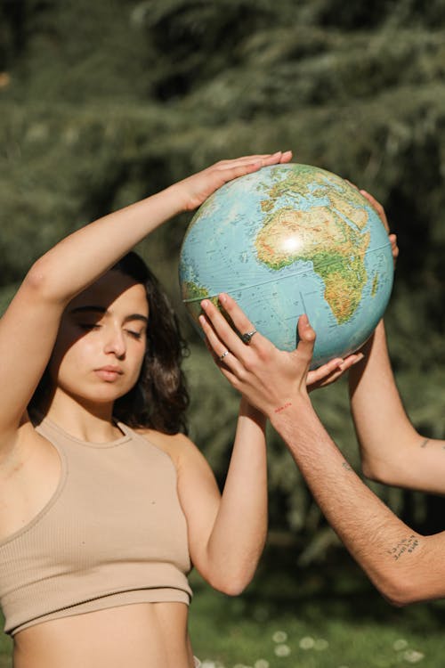 A Woman Holding a Globe with Another Person