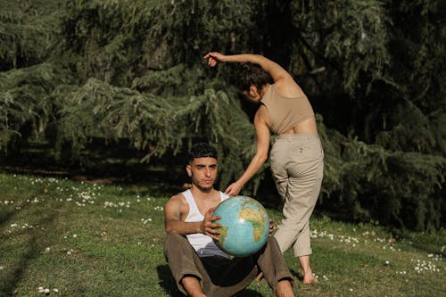 A Man Sitting while Holding a Globe