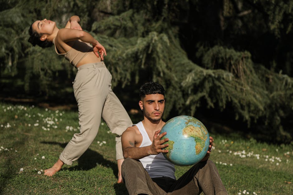 Two young adults in nature, one holding a globe, representing environmental care and sustainability.