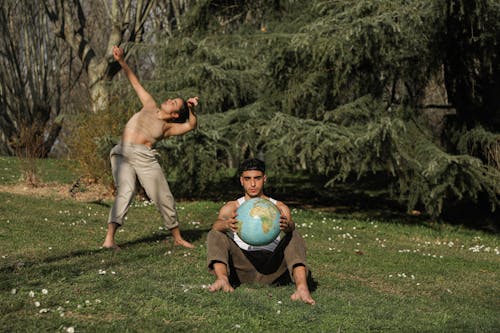 Man Holding a Globe Beside a Woman Dancing