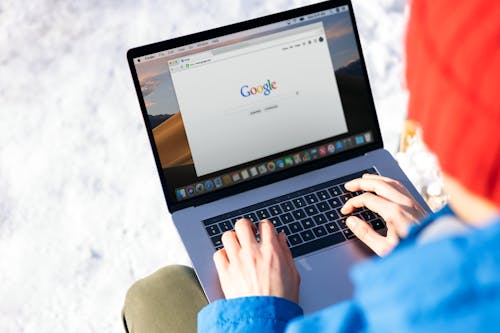 Free Person Using Macbook Pro with Google Website on Screen Stock Photo