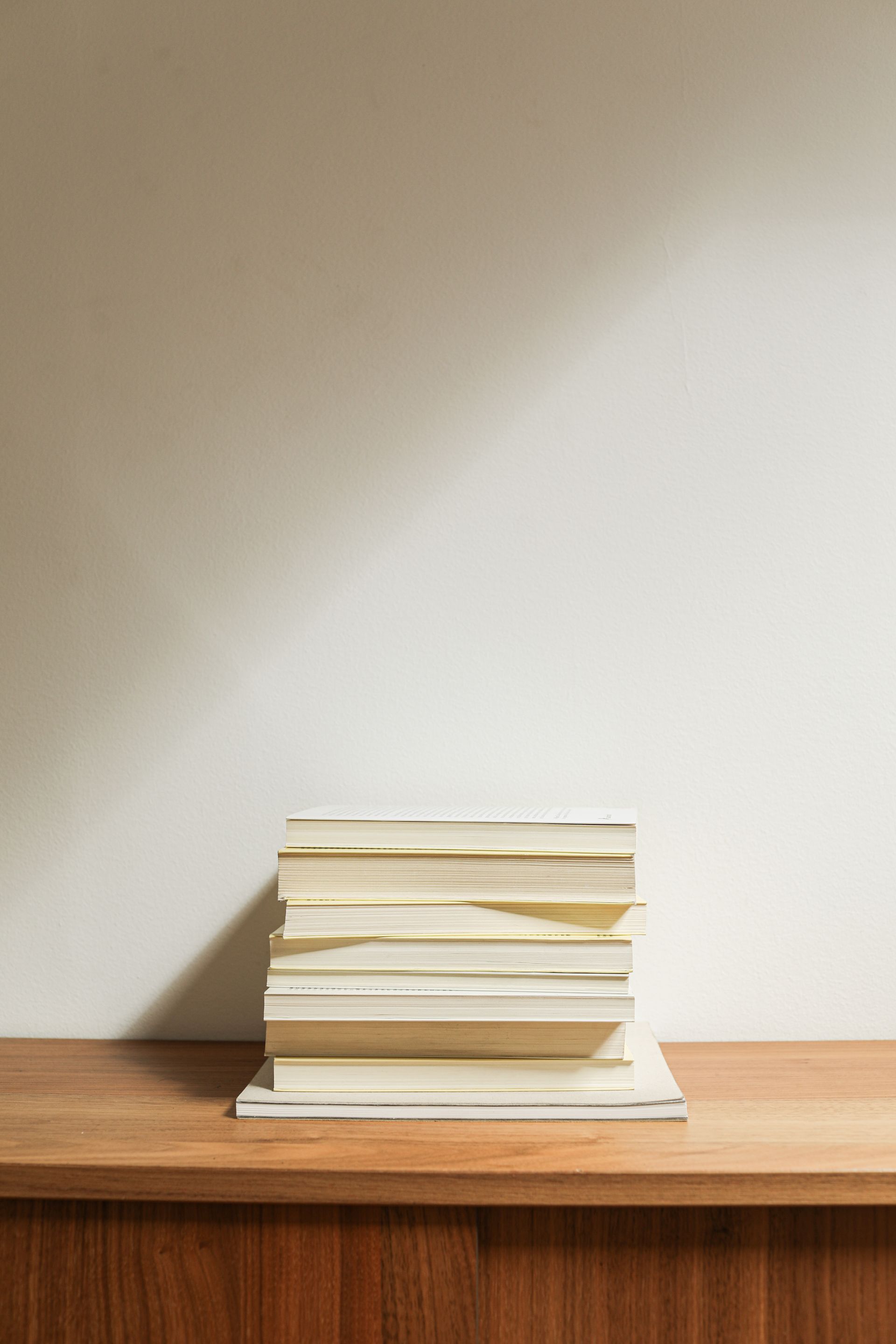 Bücherstapel mit Schreibutensilien auf einem Holzschreibtisch