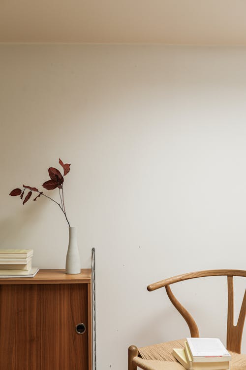 Free Pile of Books on a Chair and a Wooden Cabinet Stock Photo