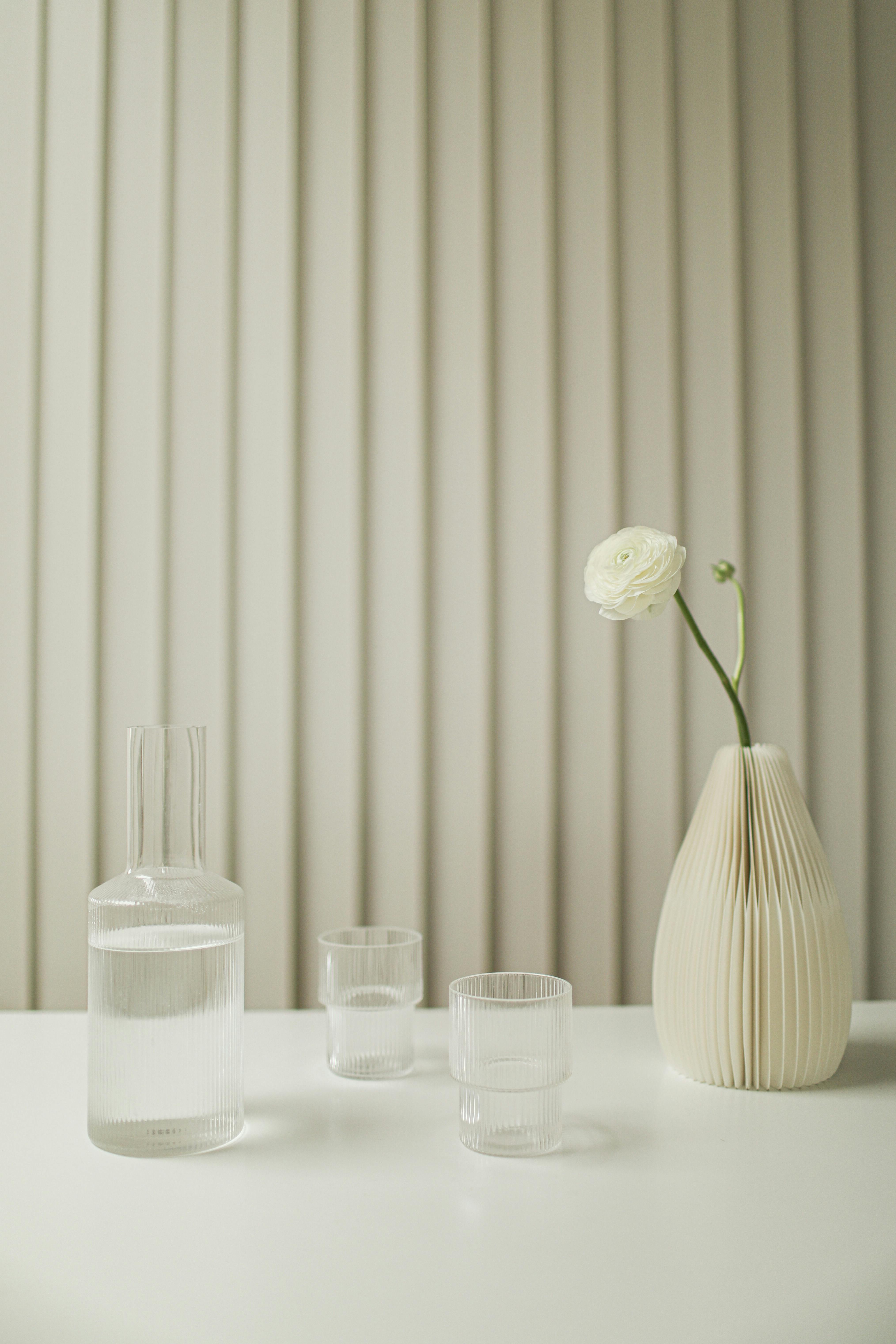 water glasses beside white flower vase with white flower