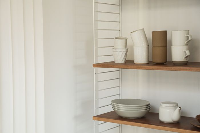 Ceramic cups and bowls on a shelf — photo by Cup of Couple on Pexels
