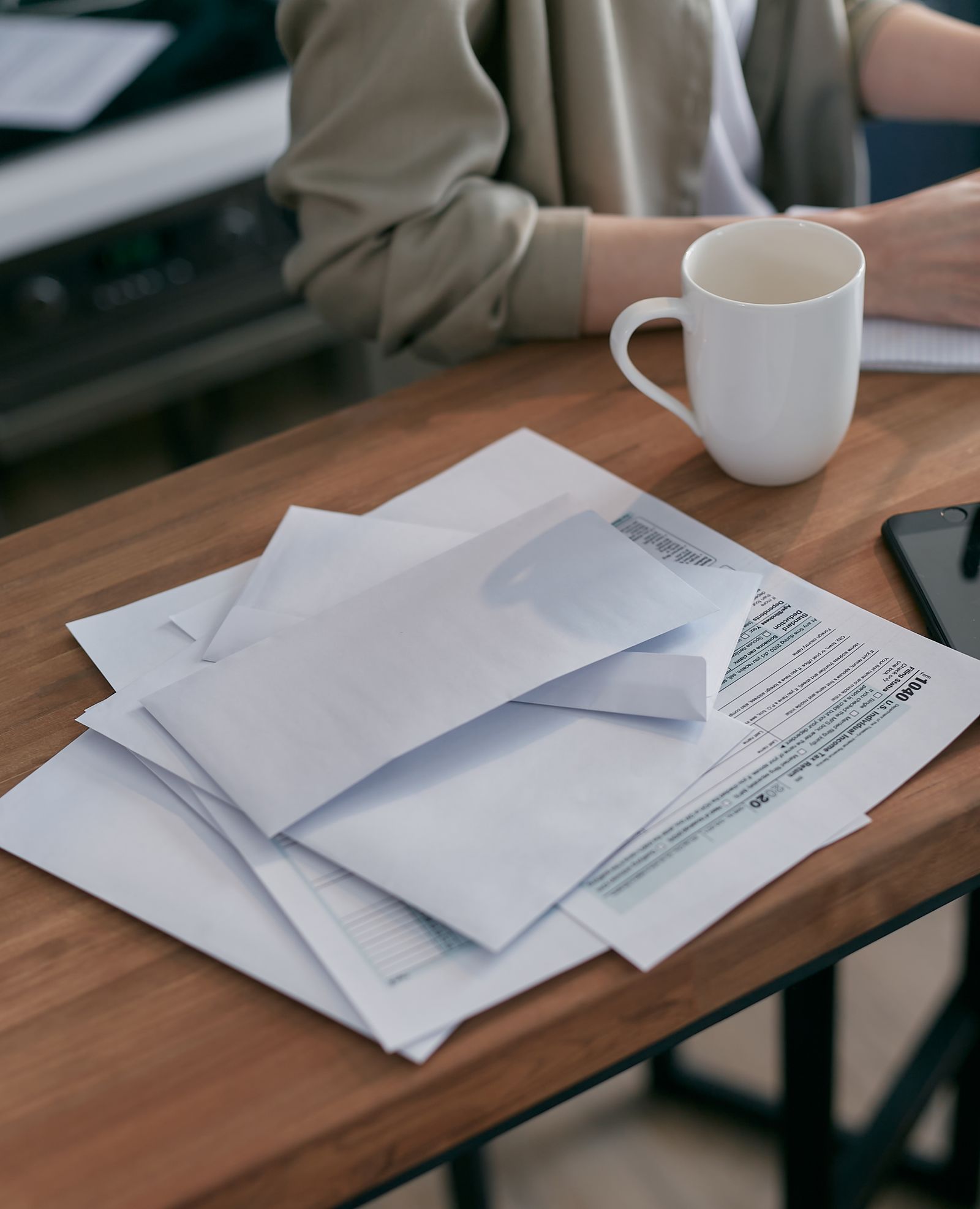 Envelopes and insurance paperwork spread on a wooden table