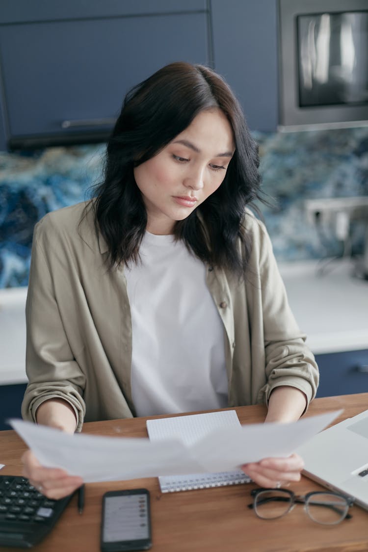 A Woman Looking At Sheets Of White Paper