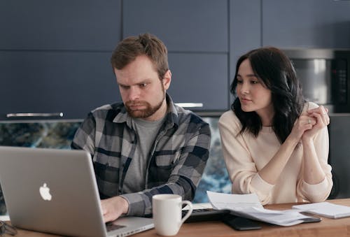 Man and Woman Looking at Laptop Screen