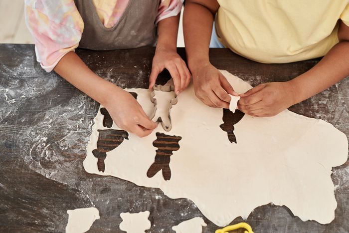 Kids cutting bunny-shaped cookies from dough