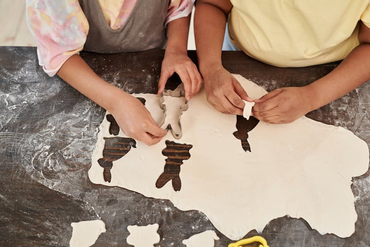 Girls Cutting Out Cookie Shapes From Dough