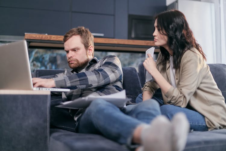 Man And Woman Sitting On Gray Couch