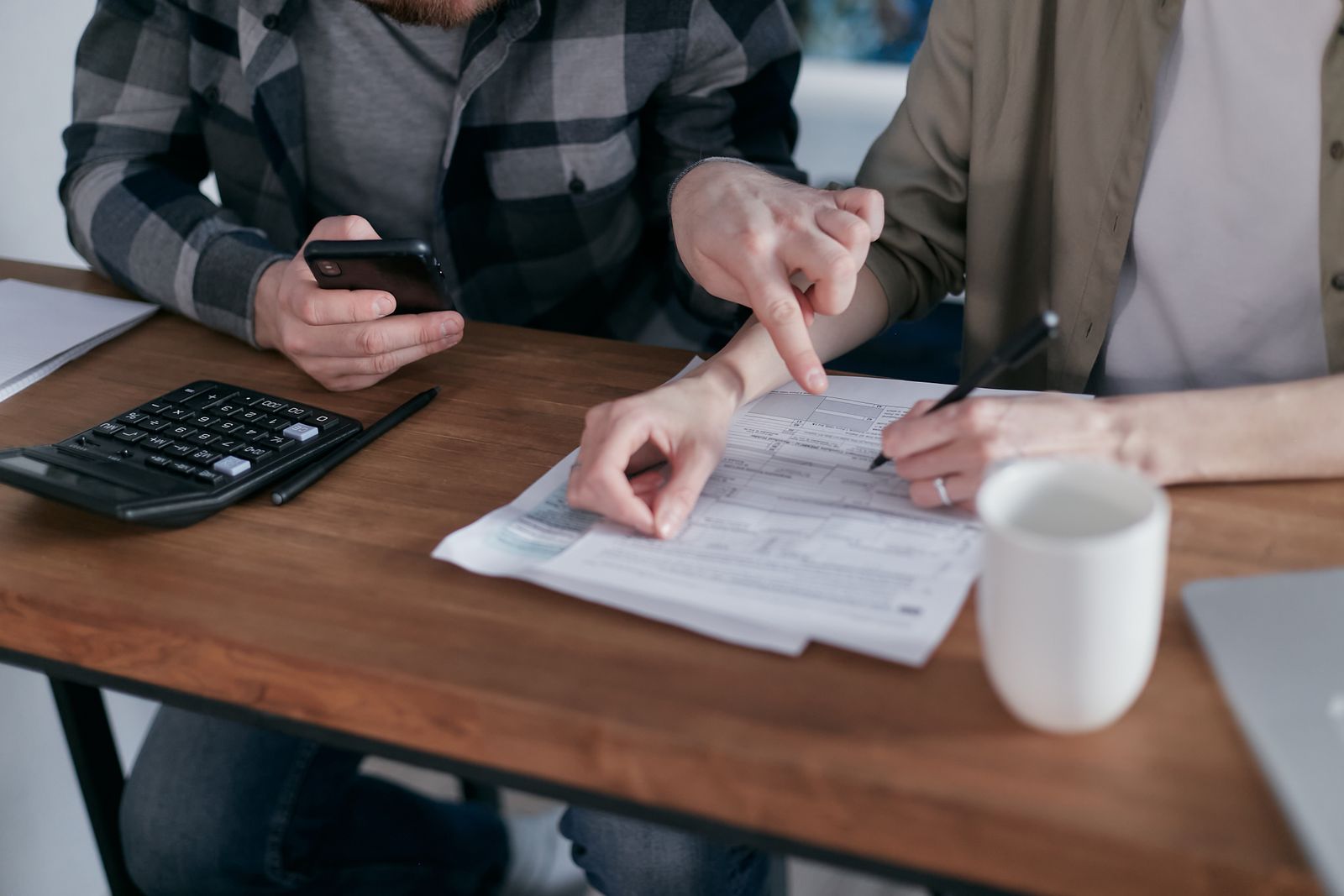 Familia estudiando documentos financieros para reorganizar sus deudas