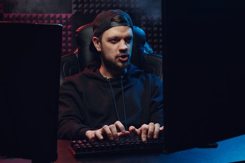 A Man with a Cap Typing on a Keyboard