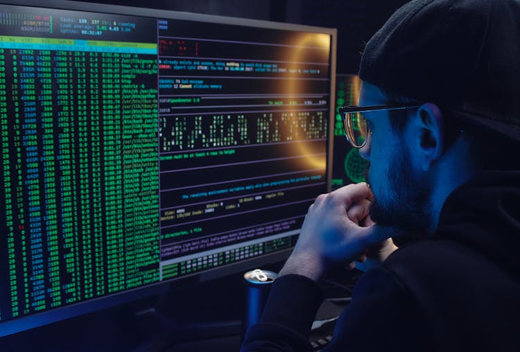 A Man Looking At A Computer Screen With Data