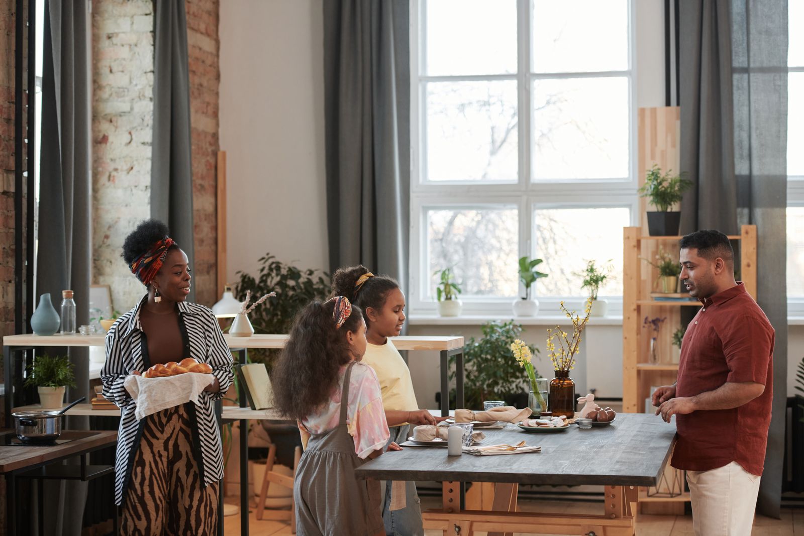 A family sharing breakfast and conversation around a kitchen table.