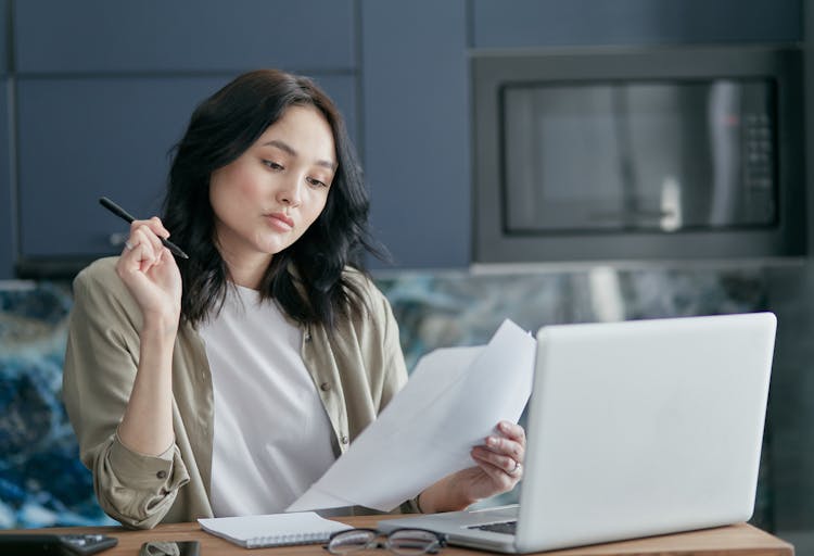 A Woman Looking At White Papers